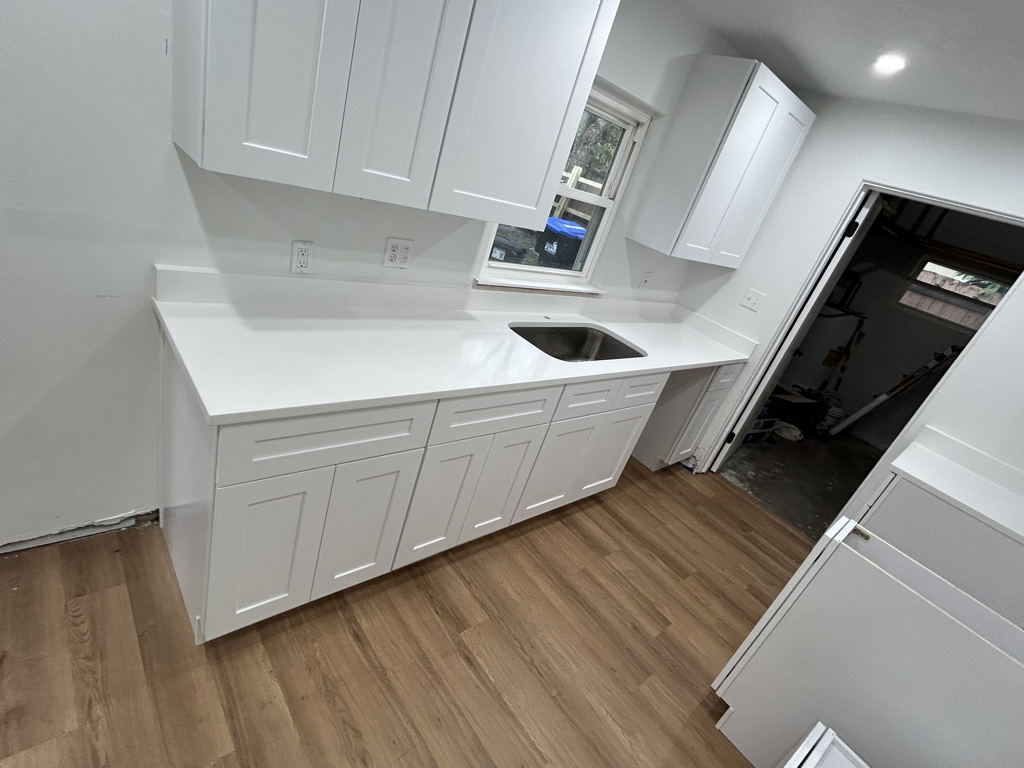 Sink under window with white cabinetry