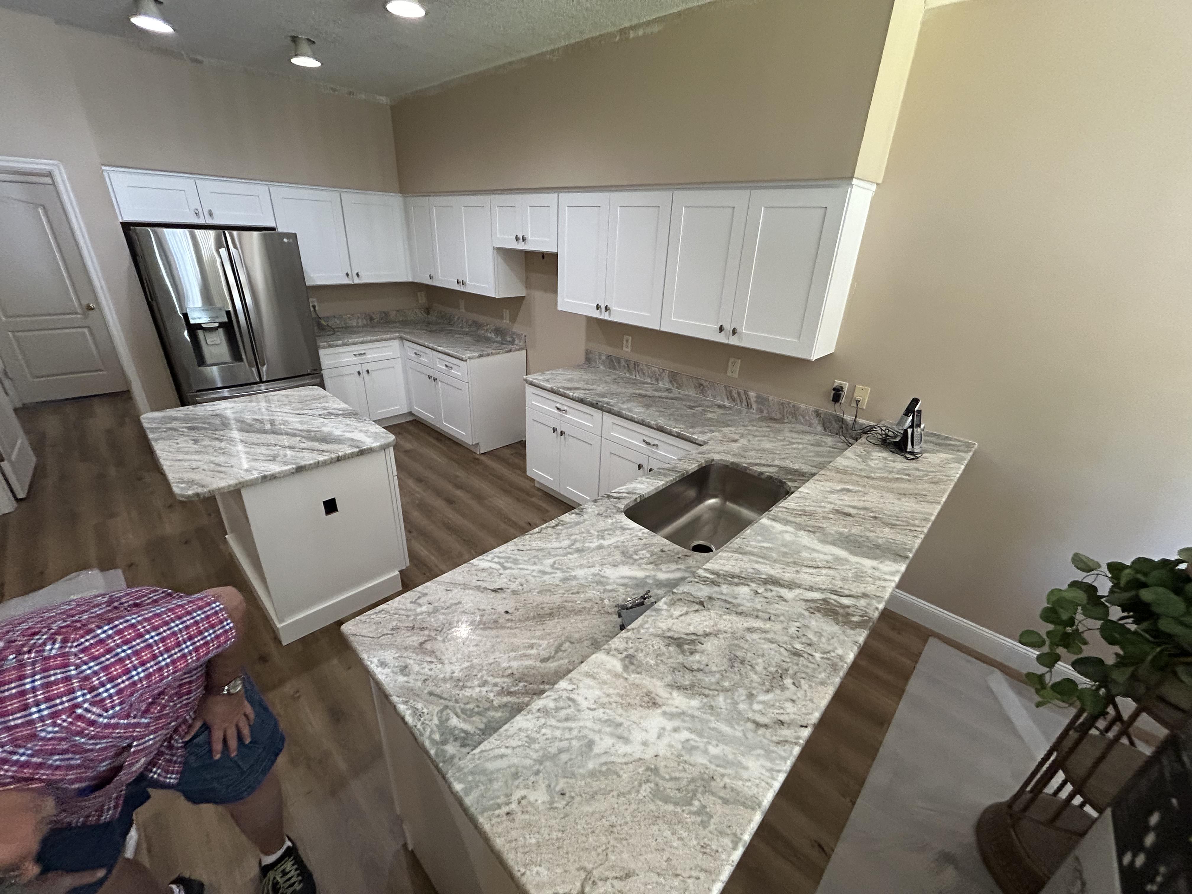 Cabinet installation progress with gray stone countertop